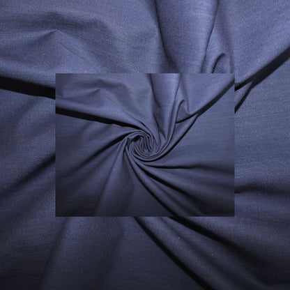 A close-up of dark navy blue fabric with a central inset showing a swirled fold pattern, highlighting the material's texture and drape.