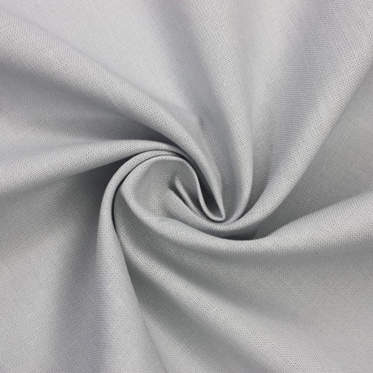 A close-up of light gray fabric arranged in a spiral drape, showing the material texture and color.