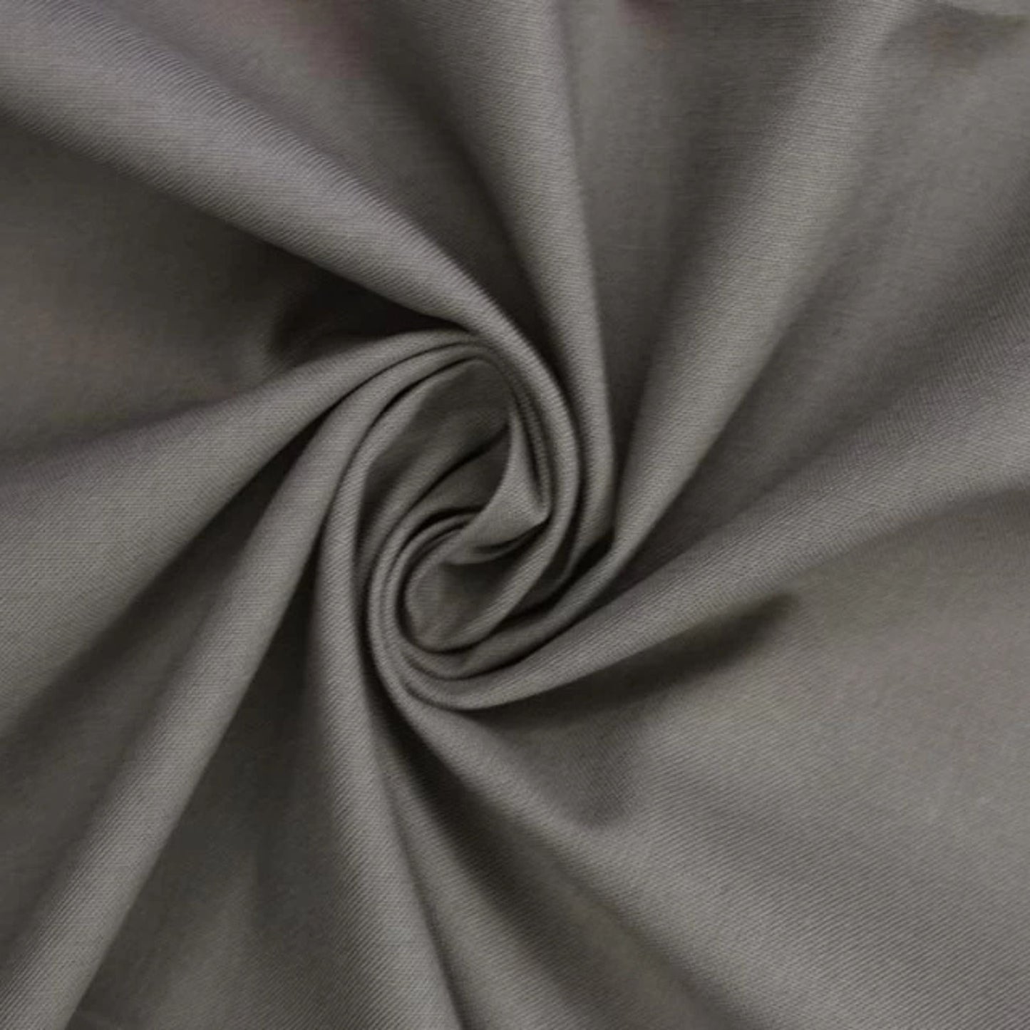 A close-up of draped gray fabric arranged in a spiral swirl, showing the material texture and color.